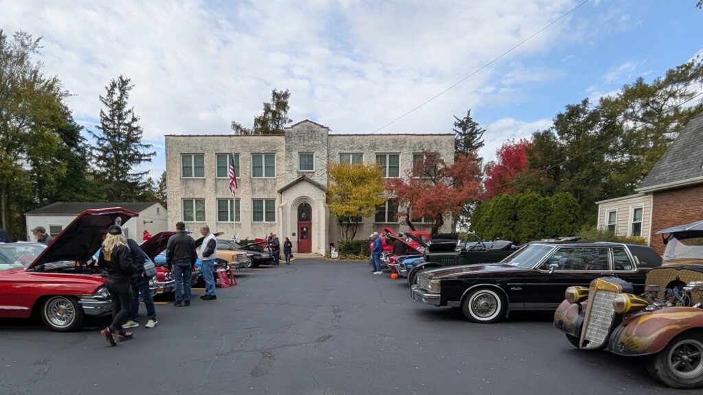 the car show with the HISTORICAL building in the background